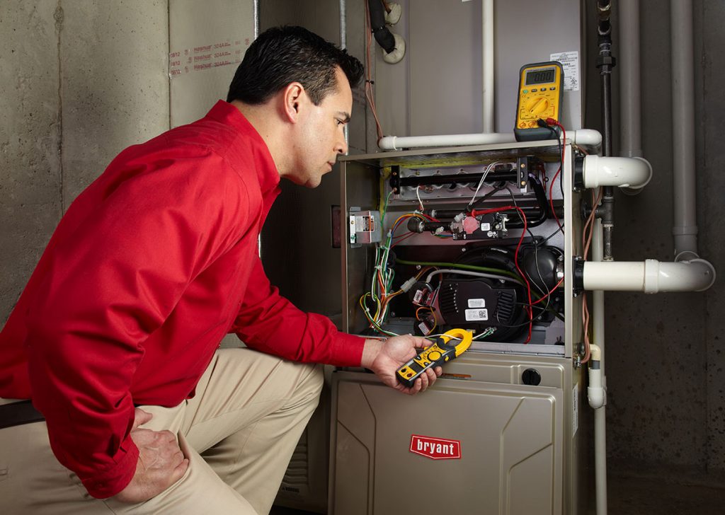 Heating and air conditioning technician servicing an indoor furnace in Gilbert, AZ