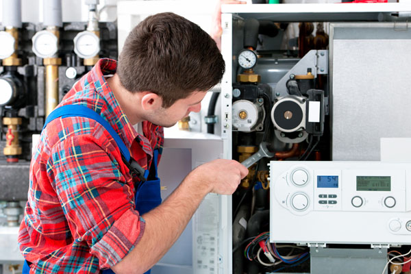 HVAC technician inspecting an indoor heating system in Gilbert, AZ