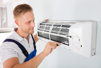 HVAC technician cleaning and repairing a ductless mini split AC in Gilbert, AZ