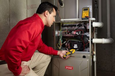 Heating and air conditioning technician servicing an indoor furnace in Gilbert, AZ